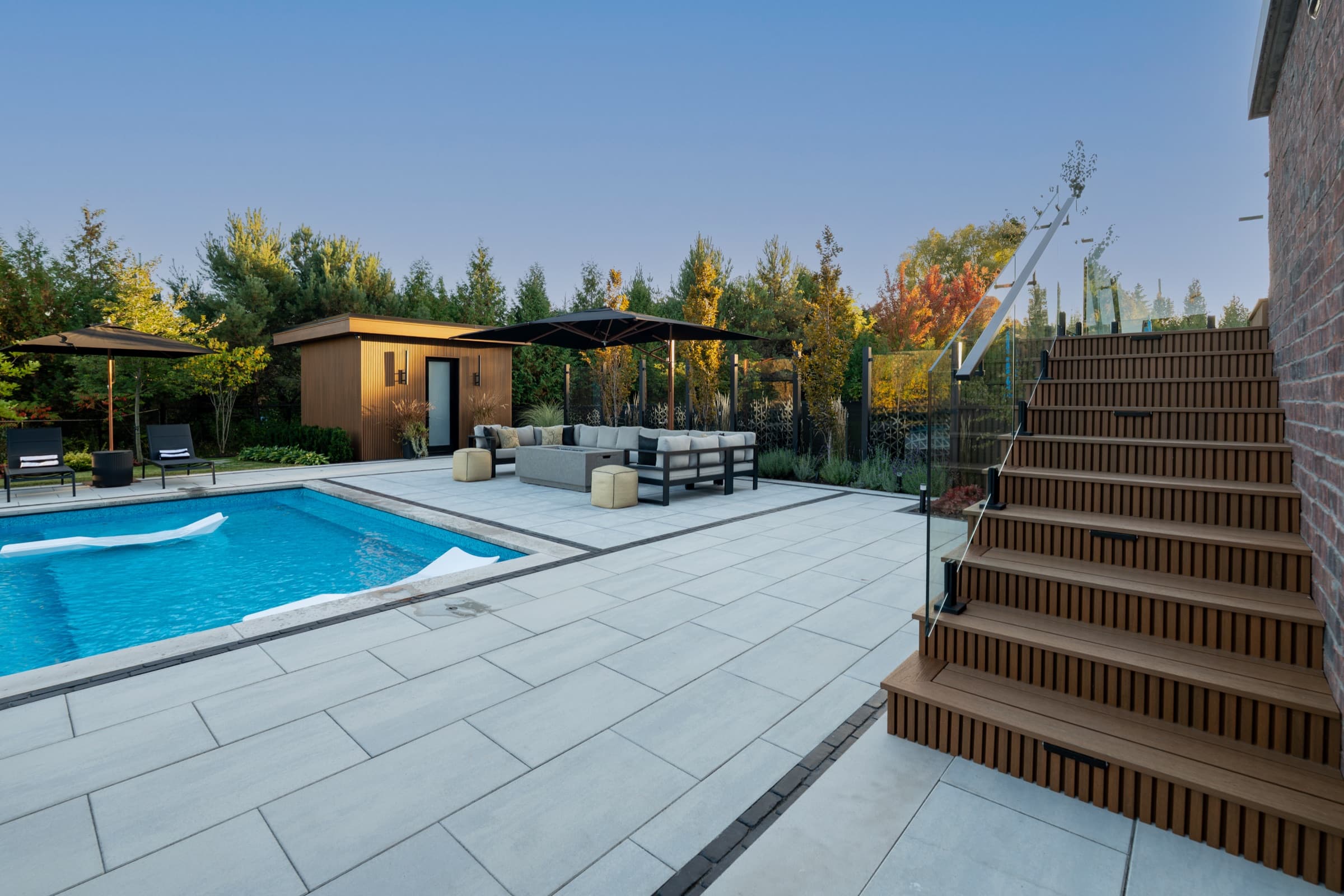 Cedar slat-clad poolside cabana and covered outdoor kitchen