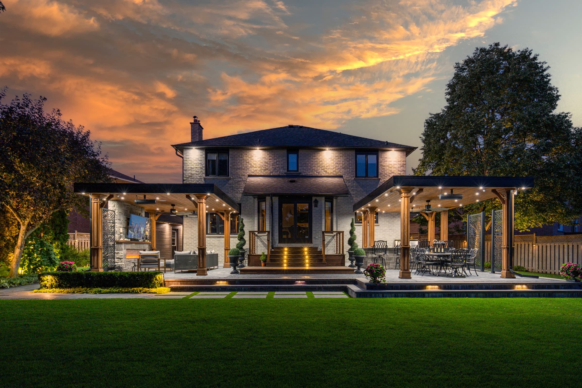 Two mirrored timber pavilions flanking a lit central staircase at sunset